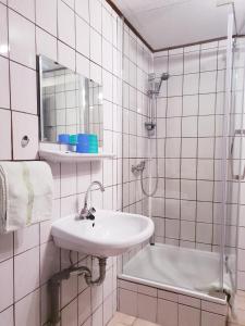 埃姆登Hotel & Restaurant Gulfhof的白色的浴室设有水槽和淋浴。