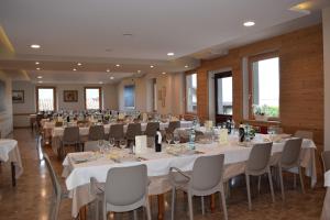 萨莱马拉西诺奥拉齐奥酒店的宴会厅配有白色的桌椅