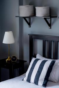 克卢日-纳波卡Downtown Wonder Apartament的一张带黑白条纹枕头和灯的床