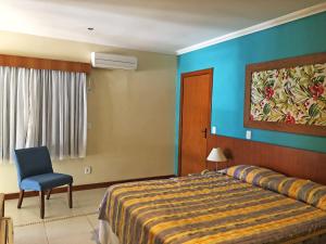 卡波布里奥Hotel Mar de Cabo Frio的一间卧室设有一张床和蓝色的墙壁