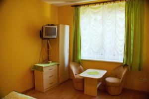 科乌切沃Wilcza Chata的客房设有桌子、电视和窗户。