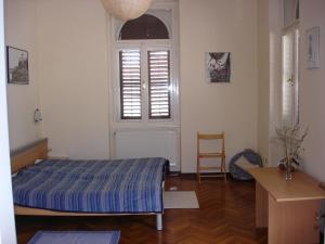奥帕提亚Green Market Apartment的一间卧室设有一张床、一个窗口和一把椅子