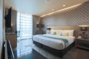 宿务bai Hotel Cebu的酒店客房设有一张大床和一台电视。
