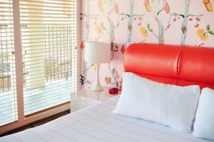 奥斯汀Austin Motel的一间卧室配有红色的床和红色床头板