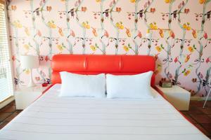 奥斯汀Austin Motel的卧室内的一张红色床和两个白色枕头
