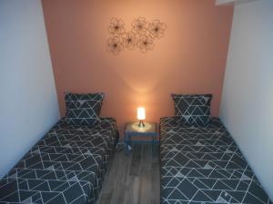 圣艾尼昂GITE DE LA PECHERIE的小型客房内的两张床,中间有灯
