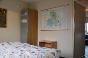 HollandscheveldAppartement Derde Zandwijkje的卧室配有一张床,墙上有地图