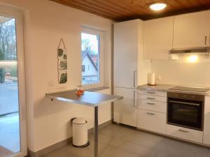 巴特施瓦尔陶Ferienwohnung im Zentrum的厨房配有白色橱柜、桌子和窗户。