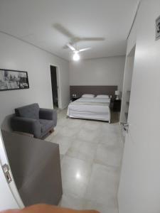 Três PontasHotel Ouro Verde的一间卧室配有一张床和一个沙发