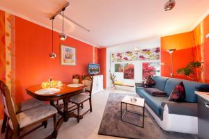 宾茨Haus Mozart的客厅设有橙色墙壁和蓝色沙发