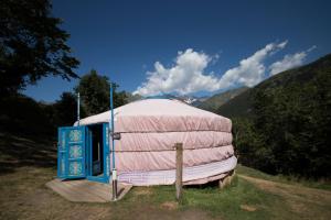 热德尔Yourtes Mongoles Gavarnie的圆顶帐篷,衬托着粉红色的盖子,位于田野中