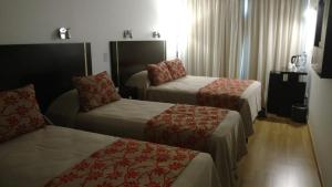 布宜诺斯艾利斯Palermo Bridge的酒店客房,配有两张床和椅子