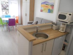 米尼赞海滩La Forêt 5的厨房配有水槽和桌椅