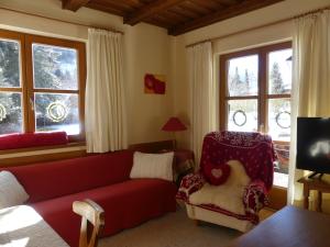 巴德小基希海姆富润沃荷芳梅里瓦斯林哲公寓的客厅配有红色的沙发和椅子