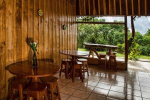 蒙泰韦尔德哥斯达黎加Cabinas Capulin & Farm的客房设有2张桌子和椅子以及窗户。