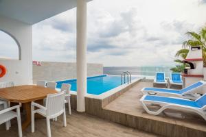 马尔萨斯卡拉The Sea-Bank Villa Apartments的别墅 - 带游泳池和桌椅