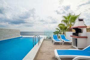 马尔萨斯卡拉The Sea-Bank Villa Apartments的一个带椅子的度假游泳池,享有海景