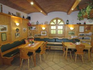 EichenbrunnArkadenhof Fam. Schneider的一间带木桌和椅子以及长凳的餐厅