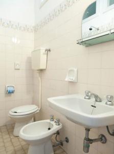 里米尼荣科尼酒店的白色的浴室设有水槽和卫生间。