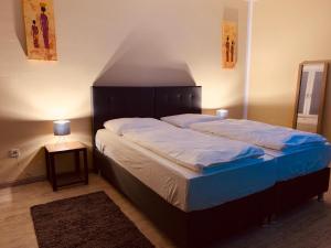 纽伦堡White Pearl Hostel 1的一间卧室配有一张大床和木制床头板