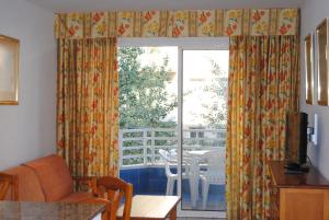 萨洛扎哈拉伦特玛公寓的客厅设有窗户,配有桌椅