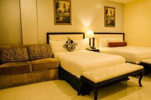 IlaganDreamwave Hotel Ilagan的酒店客房,设有两张床和一张沙发