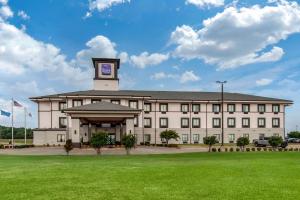 诺曼Sleep Inn & Suites Norman near University的一座大型建筑,上面有一个钟楼