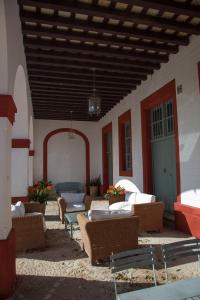 赫雷斯-德拉弗龙特拉拉卡雷尼娜乡村民宿的一座大楼内一个带沙发和椅子的庭院