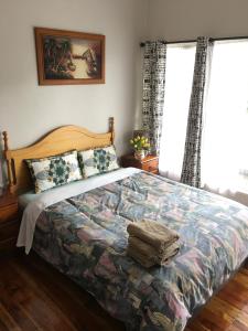 奥克兰Mini Homestay的一间卧室配有一张带五颜六色棉被的床