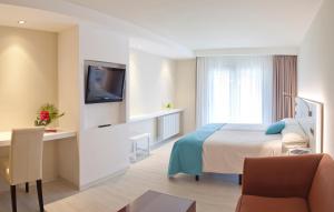 普拉加德阿罗拉特拉萨Spa酒店的一间酒店客房,配有一张床和一台电视