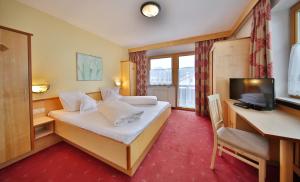 瑟弗浩斯欧泊拉赫尔公寓的酒店客房配有一张床、一张书桌和一台电视。