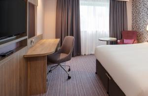 希灵登Leonardo London Heathrow Airport的酒店客房配有一张床、一张书桌和一台电视。