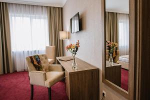 特鲁斯卡韦茨Hotel Alkor的酒店客房配有书桌、椅子和镜子