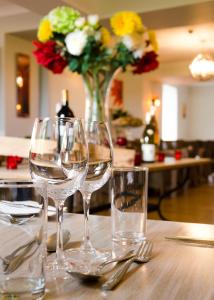 圣赫利尔泽西海浪酒店的一张桌子,上面放着三杯酒和花瓶