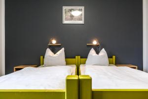 伦格里斯月亨伯格棱格里斯酒店的墙上灯的房间里设有两张床