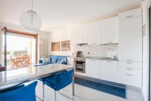加尔达湖滨Casa Davide的厨房配有白色橱柜和蓝色椅子