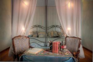 佛罗伦萨阿普丽雷帕拉索达博尔戈酒店的一间卧室配有一张带桌子和书籍的床