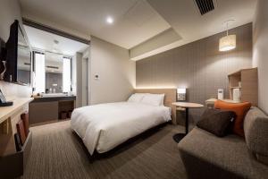 名古屋Nishitetsu Hotel Croom Nagoya的酒店客房,配有床和沙发