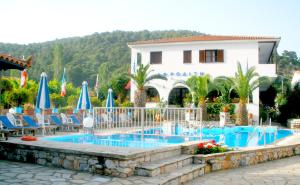 帕诺尔莫斯斯科派洛斯阿弗洛蒂提酒店的度假村的游泳池,配有椅子和遮阳伞