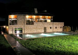 阿兰达德杜洛Hotel Rural y SPA Kinedomus Bienestar的一座建筑,在晚上前方有一个游泳池