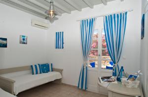 米克诺斯城格莱帕丽斯俱乐部公寓的白色的客房设有蓝色窗帘和窗户。