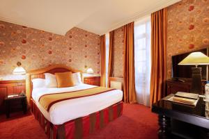 图卢兹Grand Hotel de l'Opera - BW Premier Collection的配有一张床和一张书桌的酒店客房