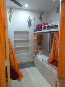 瓦拉纳西Banaras Guest House的客房设有两张双层床和橙色窗帘