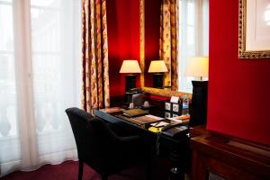图卢兹Grand Hotel de l'Opera - BW Premier Collection的红色的房间,配有书桌和红色的墙壁