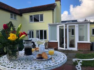 奥尔德堡Marsh View Cottage, Aldeburgh的一张桌子,上面放着一盘面包和橙汁