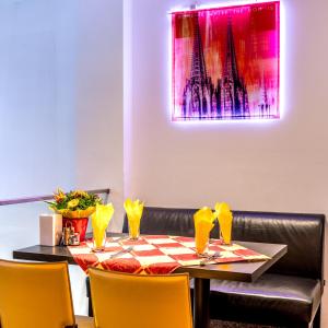 科隆科隆阿姆博物馆酒店的一张带黄色椅子和粉红色绘画的餐桌