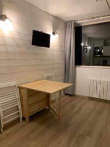 阿拉纽埃Studio des Cintes Blanques的客房设有木桌和墙上的电视。