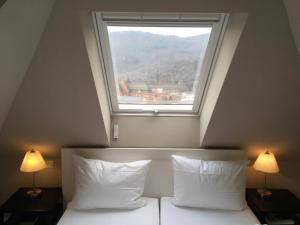 特里费尔斯山麓安韦勒Villa Waldfrieden - Gästehaus zum Jugendstilhotel的卧室配有窗户,位于床上方,配有两盏灯