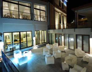 西格纳吉卡巴都尼精品酒店的大楼内的阳台配有白色的桌椅