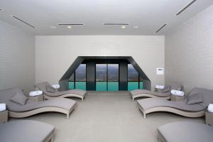 西格纳吉卡巴都尼精品酒店的一间设有白色椅子和大窗户的等候室